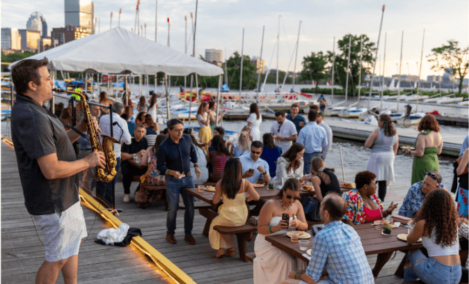 Guests gathered at the river dock for the Summer Dock Party at golden hour